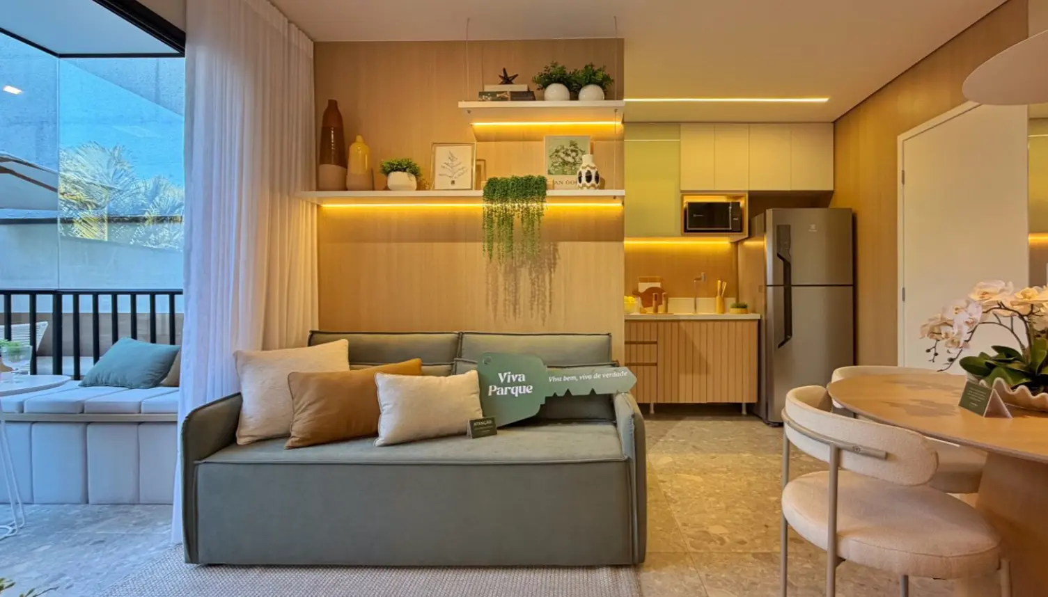 Sala de estar do apartamento decorado do Viva Parque Aura com sofá e painel de madeira